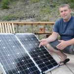 man standing near solar panel