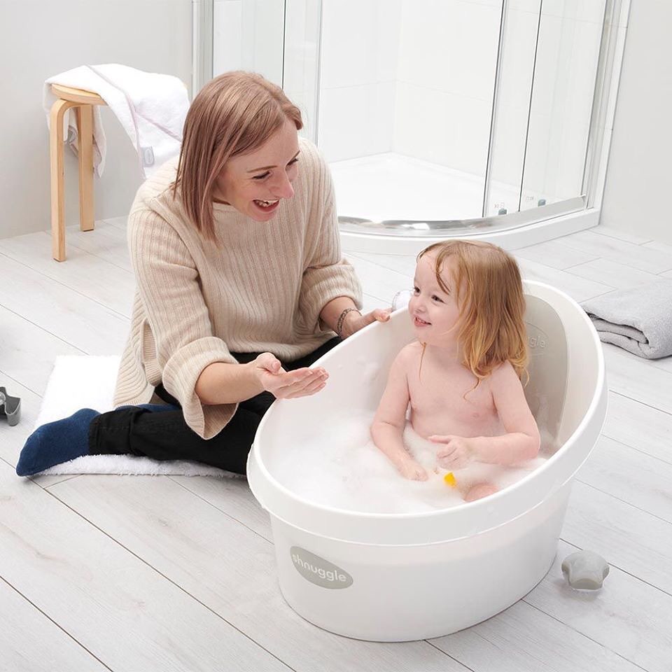 mother bathing her baby in a baby ba