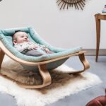 picture of a baby in a wooden bouncer seat