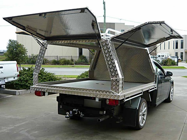 picture of an ute with aluminum canopy  on a parking lot 