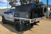 picture of an ute with a black canopy on a road
