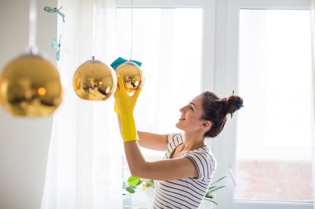 woman cleaning her lighting fixtures