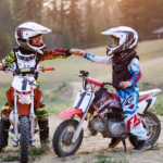 Two kids on different motorcycles greets each other