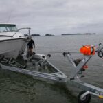 man transports his boat to and from the water with a boat trailer winch.