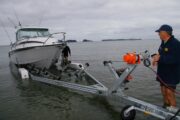 man transports his boat to and from the water with a boat trailer winch.