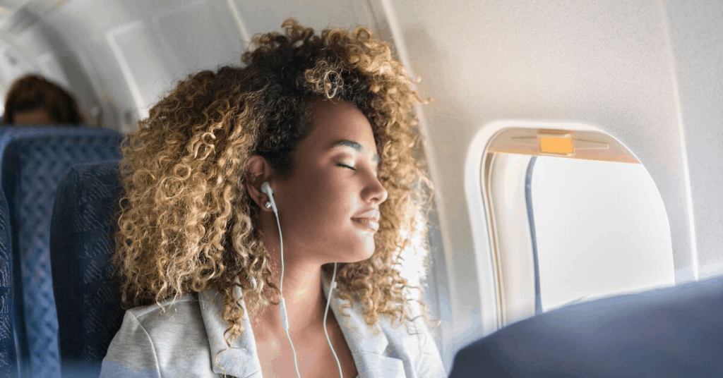 a woman sleeps on a plane with headphones