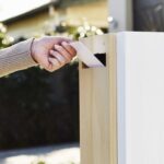 woman putting on a letter in the white letter box