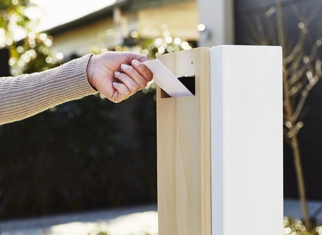 woman putting on a letter in the white letter box